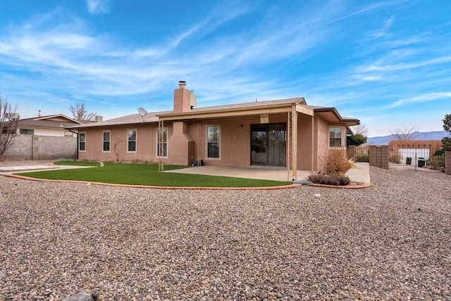 back of property featuring a yard, a gate, a patio, and fence