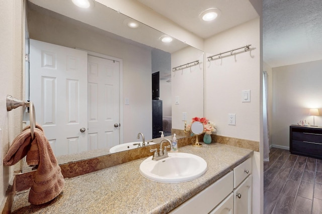 bathroom featuring wood finish floors, vanity, and recessed lighting