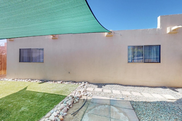 exterior space featuring a lawn and stucco siding