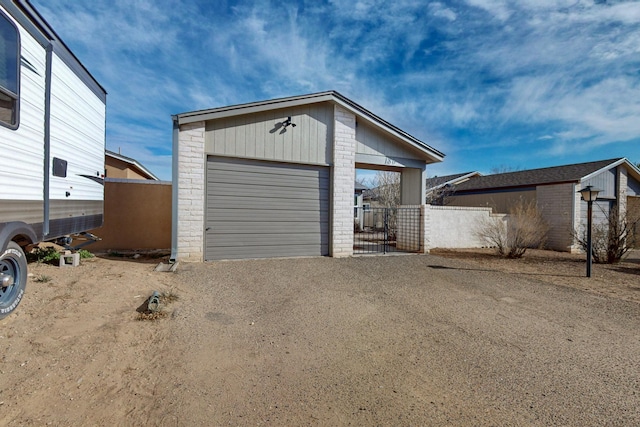 view of front of property with a garage, an outbuilding, fence, and driveway