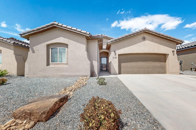 mediterranean / spanish-style home with an attached garage, a tiled roof, stucco siding, and driveway