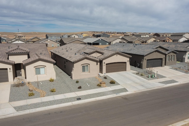 view of front of property with driveway, stucco siding, a garage, a tiled roof, and a residential view