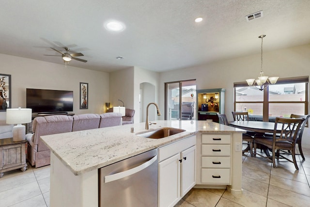 kitchen featuring dishwasher, light stone countertops, light tile patterned floors, and a sink