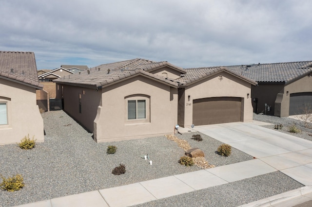 view of front of home with a tile roof, concrete driveway, a garage, and stucco siding