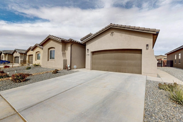 mediterranean / spanish-style home featuring stucco siding, a tiled roof, concrete driveway, and a garage