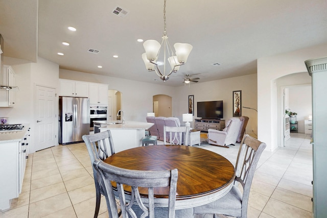 dining area with recessed lighting, visible vents, arched walkways, light tile patterned flooring, and ceiling fan with notable chandelier