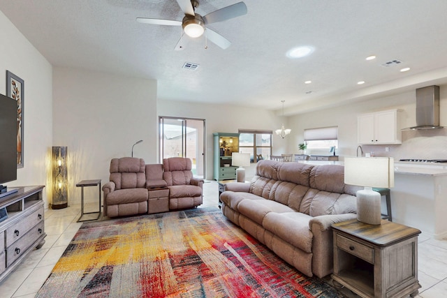 living area with ceiling fan, visible vents, a wealth of natural light, and light tile patterned floors