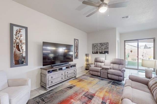 living area featuring light tile patterned flooring, visible vents, and a ceiling fan