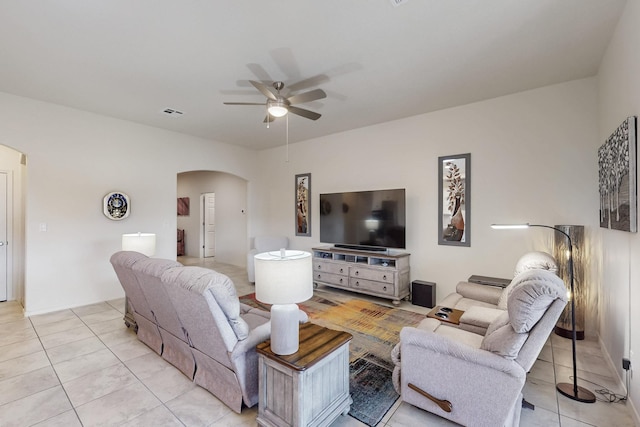 living room featuring arched walkways, light tile patterned floors, visible vents, and ceiling fan