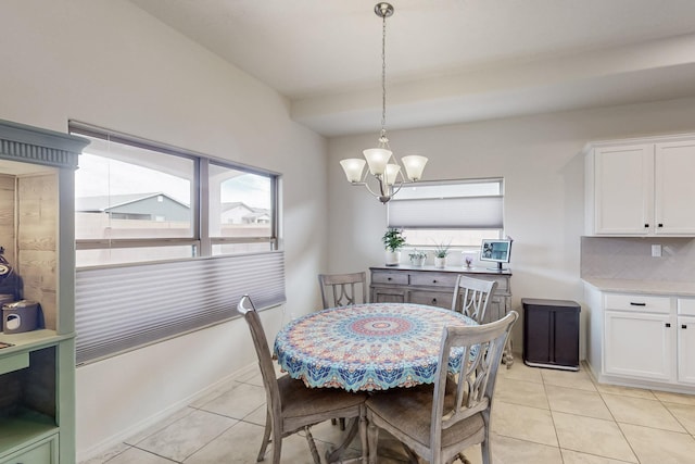 dining space with light tile patterned floors, baseboards, and an inviting chandelier