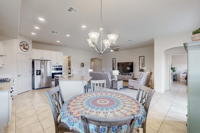 dining space featuring light tile patterned floors, visible vents, and arched walkways