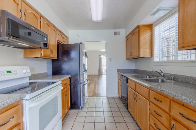 kitchen with light tile patterned flooring, electric range, a sink, visible vents, and dishwasher