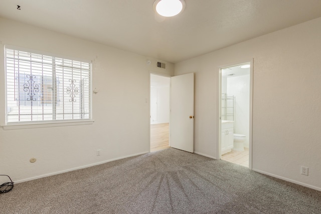 carpeted spare room featuring visible vents and baseboards