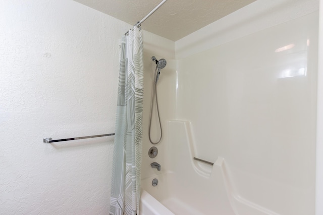 bathroom featuring a textured wall and shower / bath combo with shower curtain