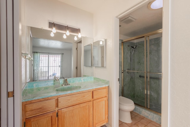 bathroom featuring visible vents, toilet, a shower stall, vanity, and tile patterned flooring