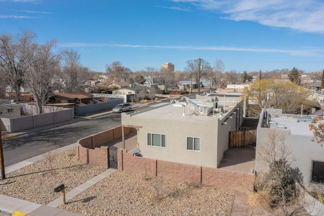 exterior space featuring a residential view, fence, and stucco siding