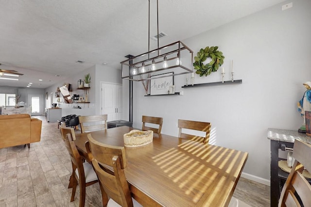 dining area featuring ceiling fan, wood finished floors, visible vents, and baseboards