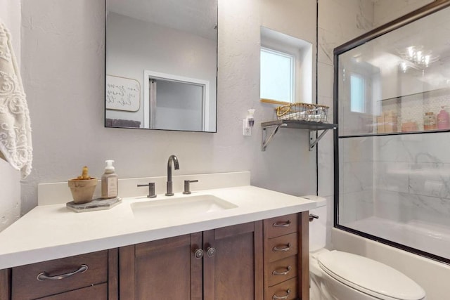 full bath featuring toilet, shower / bath combination with glass door, and vanity