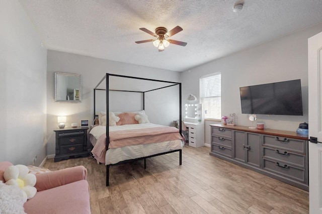 bedroom featuring a textured ceiling, a ceiling fan, and light wood-style floors