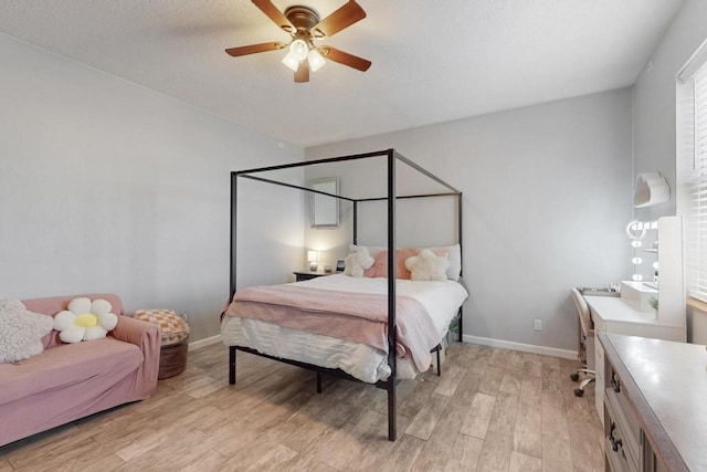 bedroom featuring light wood-type flooring, baseboards, and a ceiling fan