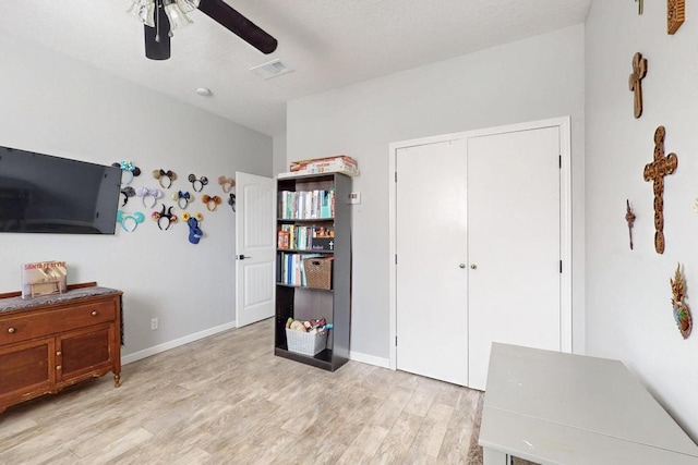 bedroom with a ceiling fan, baseboards, visible vents, light wood-style floors, and a closet