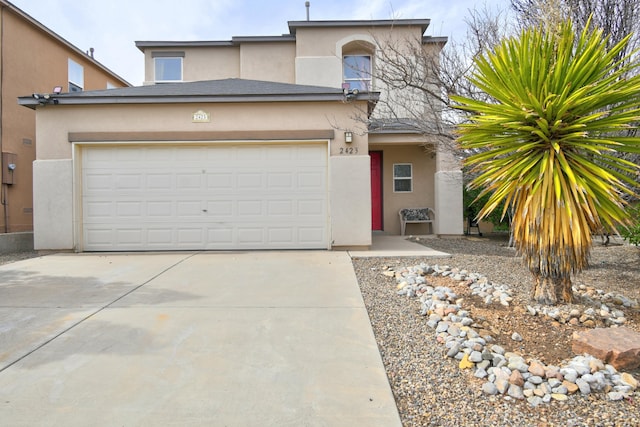 view of front of home with driveway, an attached garage, and stucco siding