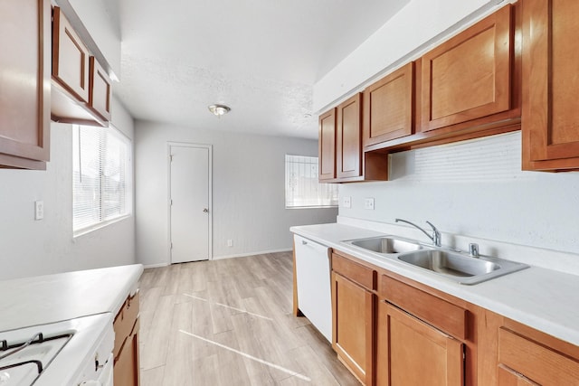 kitchen featuring white appliances, light wood-style floors, light countertops, and a sink