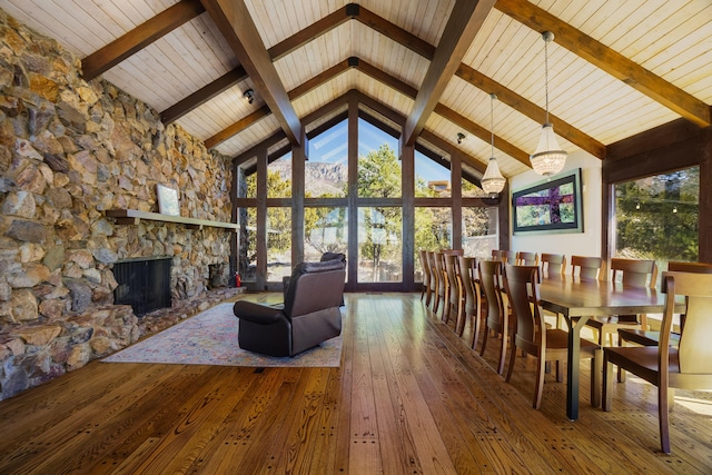 living room with hardwood / wood-style flooring, a fireplace, high vaulted ceiling, and beam ceiling