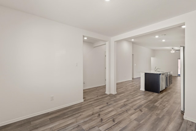 interior space featuring baseboards, ceiling fan, wood finished floors, a sink, and recessed lighting