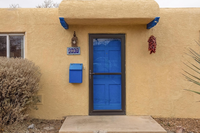 entrance to property with stucco siding