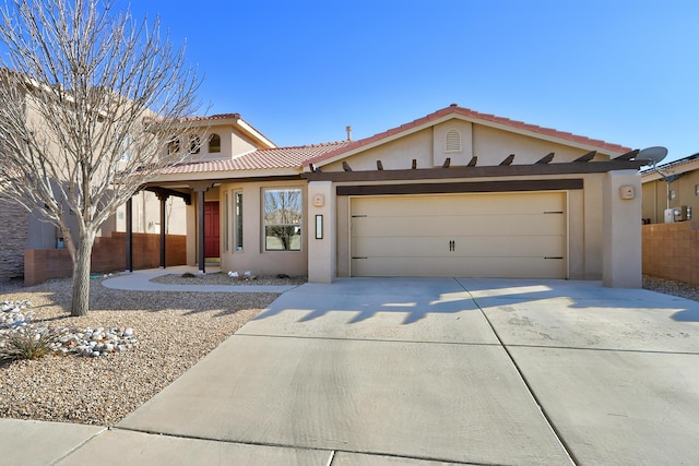 view of front of home with concrete driveway, a tiled roof, an attached garage, and stucco siding