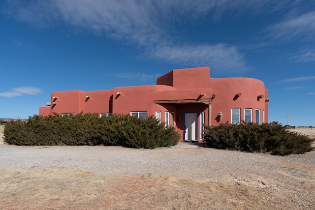 pueblo revival-style home with stucco siding