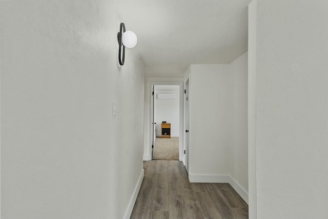 hallway featuring baseboards and wood finished floors