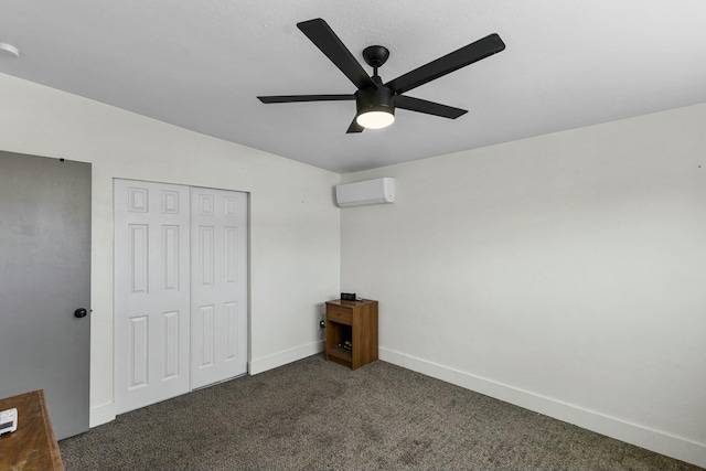 unfurnished bedroom with ceiling fan, a wall unit AC, baseboards, a closet, and dark carpet