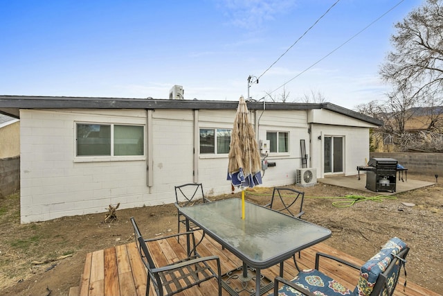 back of property featuring a patio, outdoor dining area, ac unit, and concrete block siding