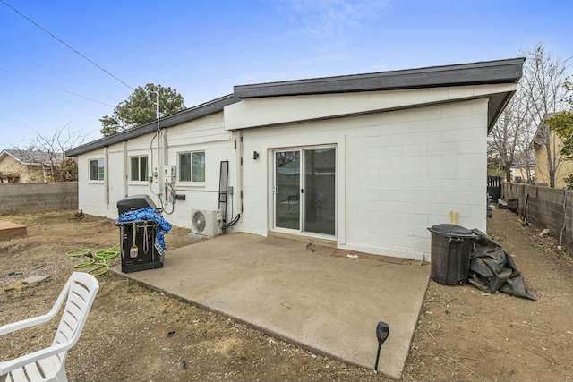 back of property featuring ac unit, a fenced backyard, a patio area, and concrete block siding