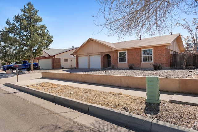 single story home featuring an attached garage, brick siding, fence, driveway, and board and batten siding