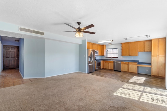 kitchen with ceiling fan, a textured ceiling, light colored carpet, visible vents, and appliances with stainless steel finishes