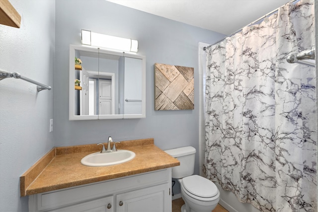 bathroom featuring curtained shower, vanity, and toilet