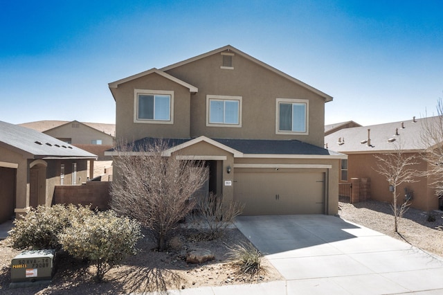 view of front of property featuring concrete driveway, an attached garage, and stucco siding