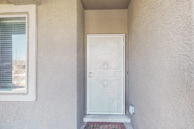 entrance to property featuring stucco siding