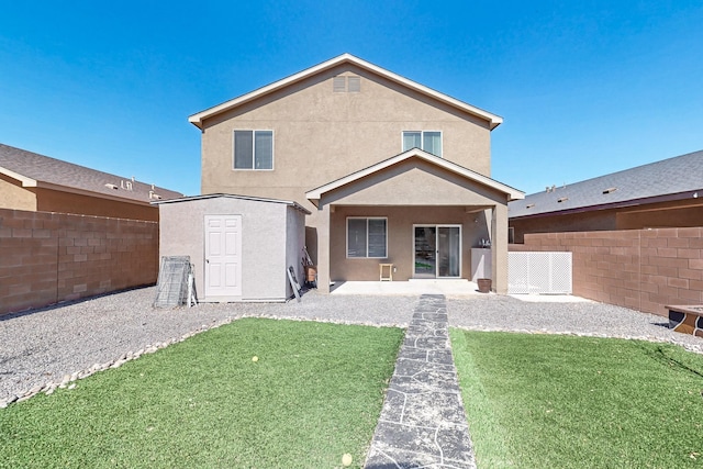 rear view of house featuring a shed, fence, an outdoor structure, and stucco siding