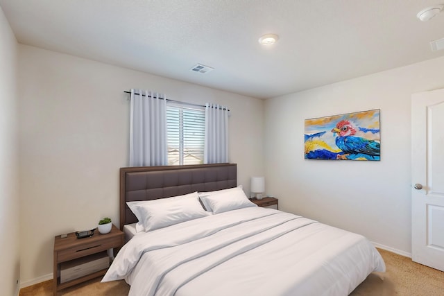 bedroom with baseboards, visible vents, and light colored carpet