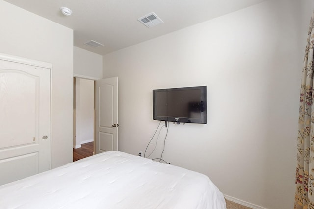 bedroom with baseboards and visible vents