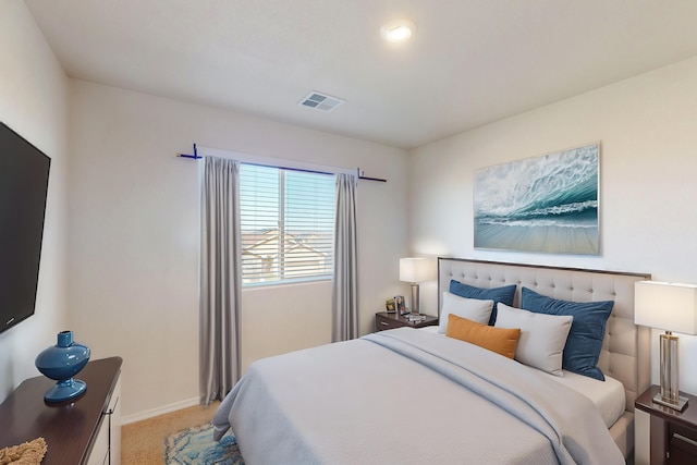 bedroom with baseboards, visible vents, and light colored carpet