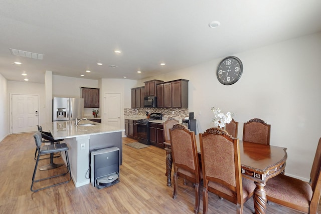 dining room featuring light wood finished floors, visible vents, and recessed lighting