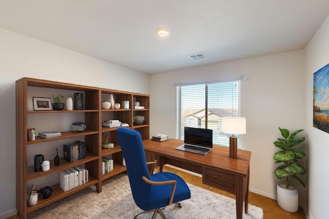 home office featuring visible vents, light carpet, and baseboards