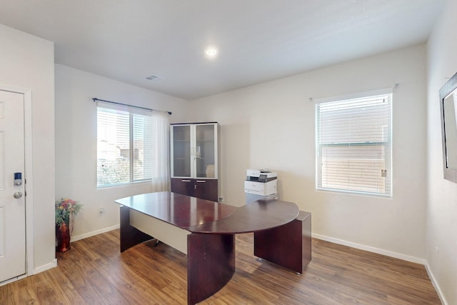 office with visible vents, baseboards, and wood finished floors