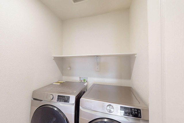 clothes washing area with laundry area, separate washer and dryer, and visible vents