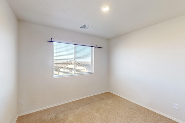 unfurnished room featuring carpet, visible vents, and baseboards